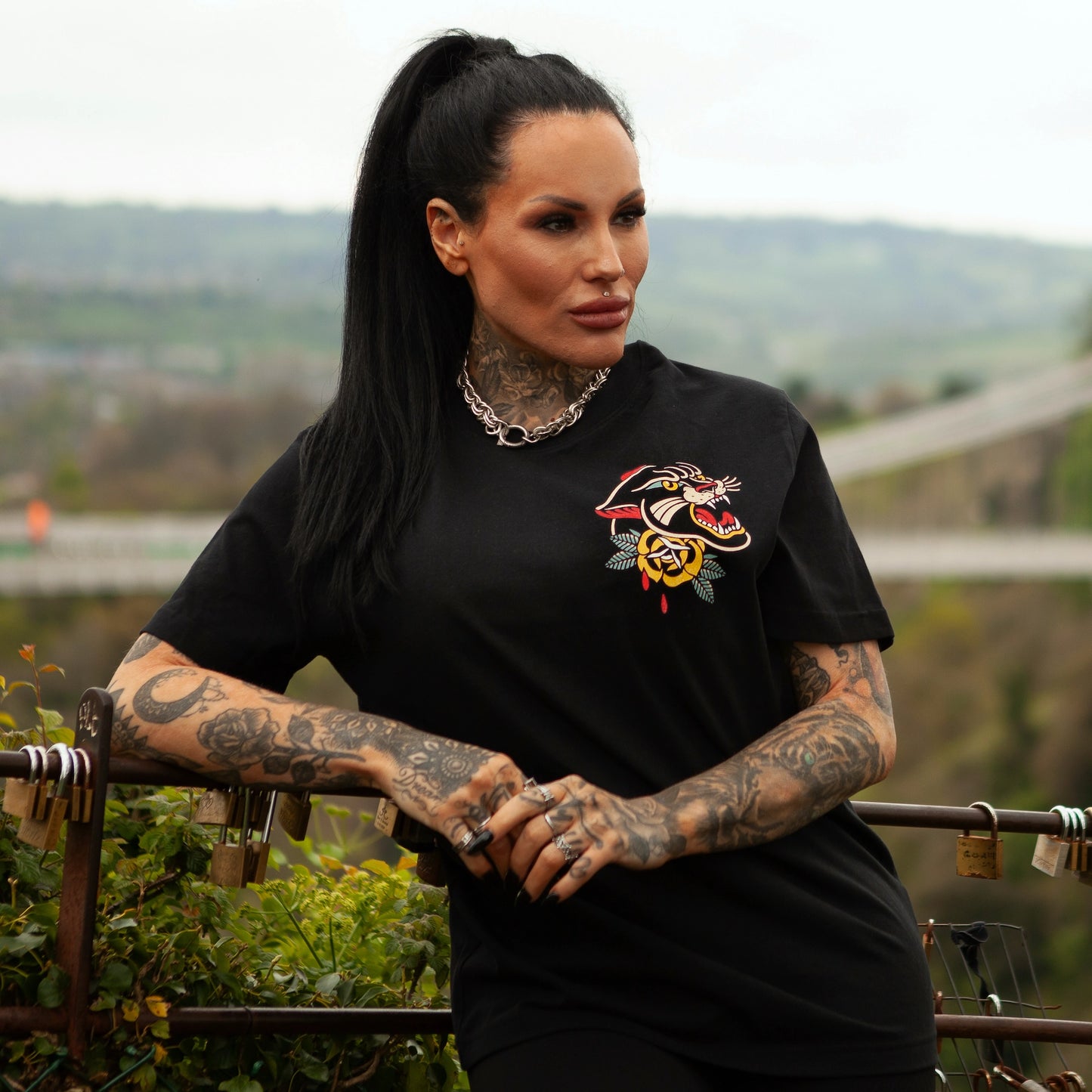 Model wearing the Pocket Panther t-shirt at the Bristol observatory, showcasing the bold tattoo-style panther and rose chest design.