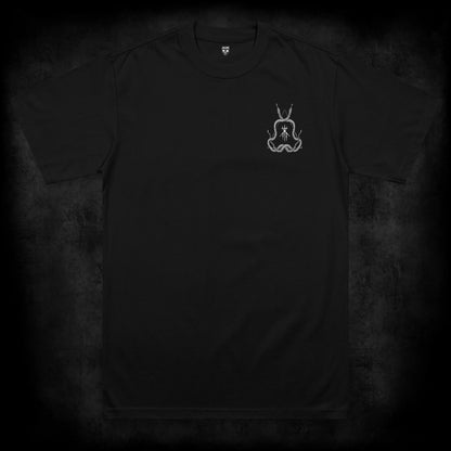 Front view of the Dormant occult t-shirt featuring a small left chest print of intertwined serpents surrounding a ritual sigil and triangle symbol on a black heavyweight garment.