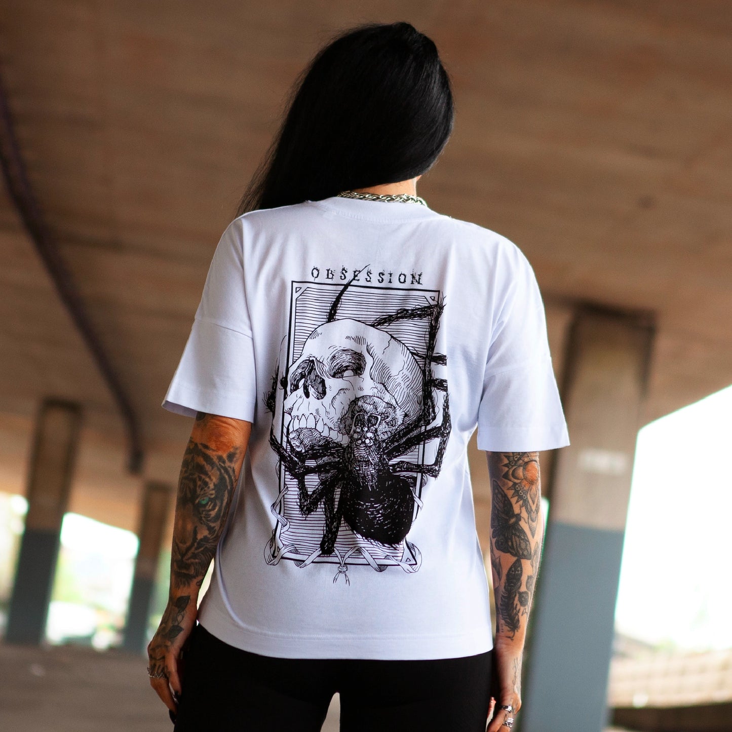 Back view of Haunt's Obsession premium t-shirt featuring a bold skull and spider illustration in black ink.