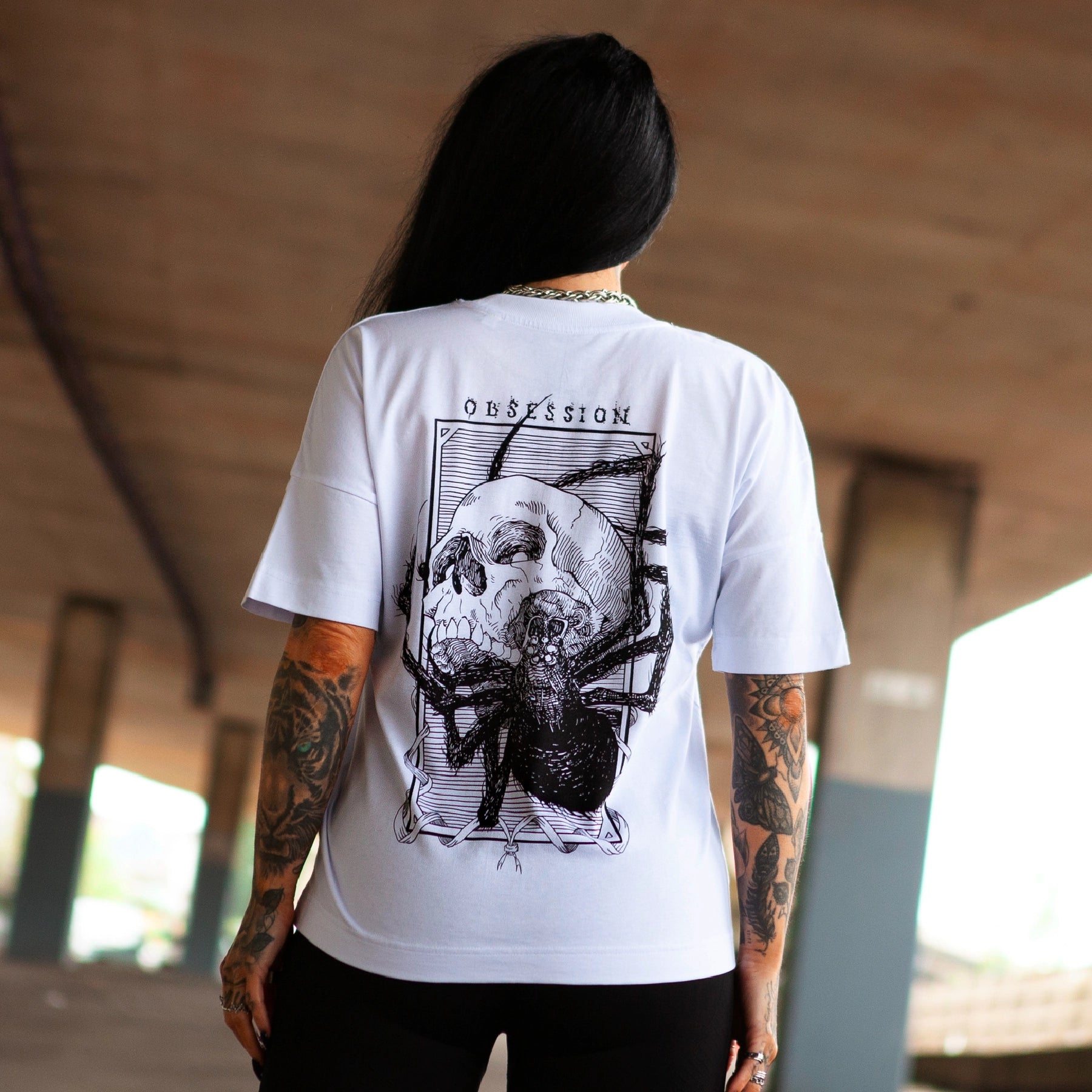 Back view of Haunt's Obsession premium t-shirt featuring a bold skull and spider illustration in black ink.