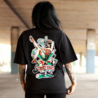 Model wearing Haunt’s Man’s Ruin oversized black t-shirt featuring a bold pin-up girl in a martini glass back print, captured under an overpass in Bristol.