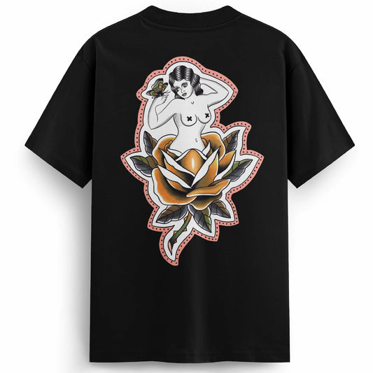Back of the Softcore Bloom tee showing a pastel traditional rose with a topless woman blooming from it, holding a butterfly. Feminine, vintage-inspired tattoo design with soft pinks and bold linework.