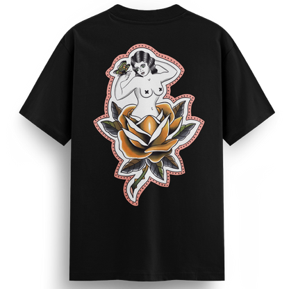 Back of the Softcore Bloom tee showing a pastel traditional rose with a topless woman blooming from it, holding a butterfly. Feminine, vintage-inspired tattoo design with soft pinks and bold linework.